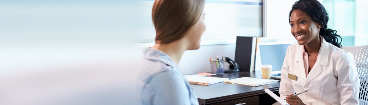 Healthcare professional listening to patient and taking notes.