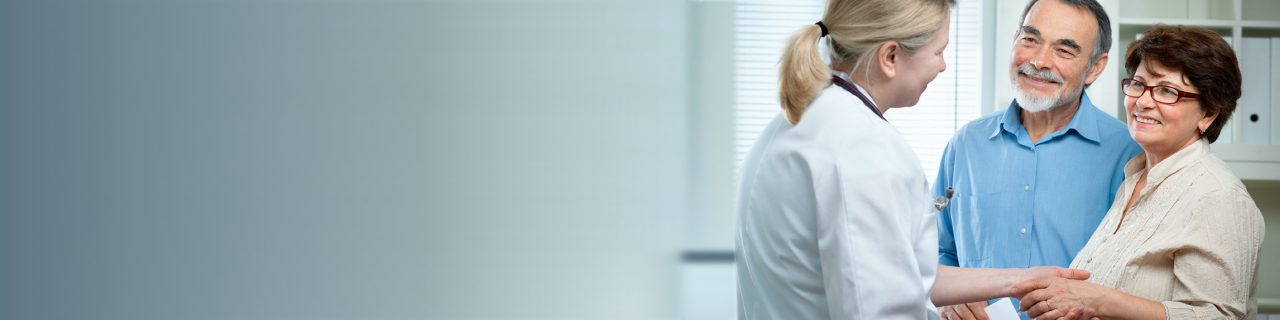 Healthcare professional in discussion with smiling couple.