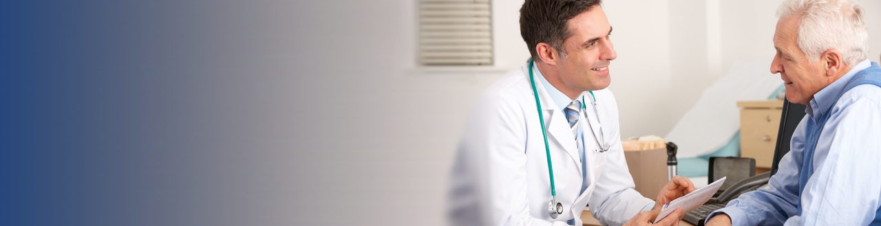 Doctor smiling at elderly patient in hospital room.